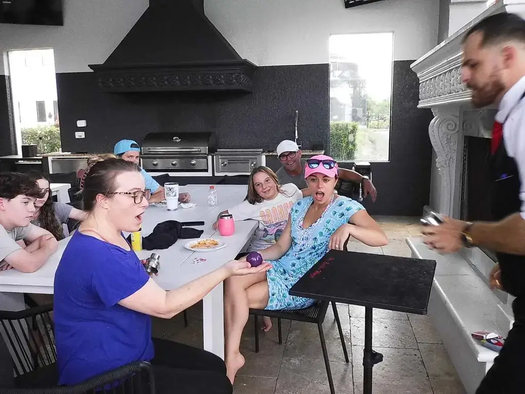 Guests watching strolling magic at a party